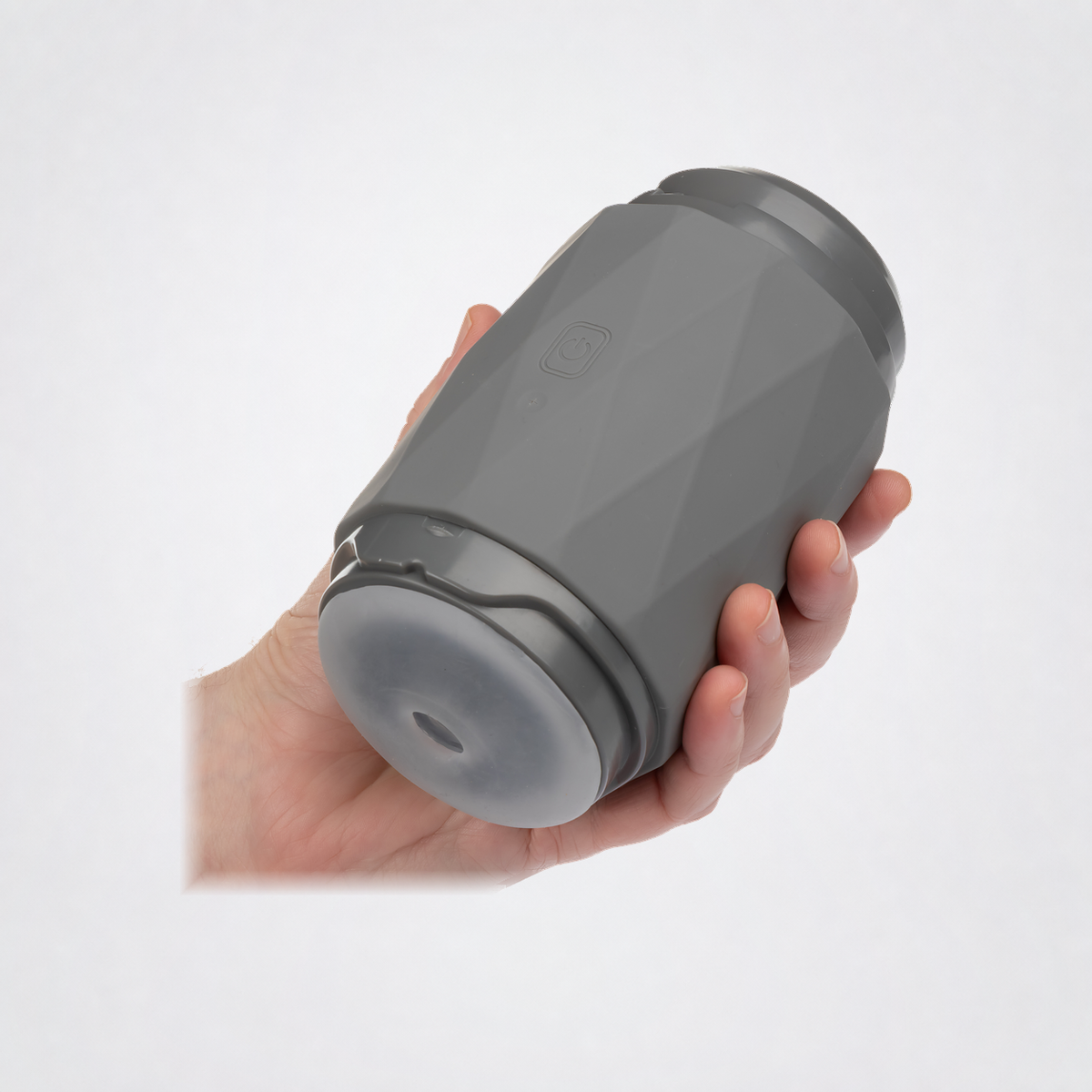 Vibro Squeeze Rechargeable Silicone Stroker shown in hand without a floor shadow