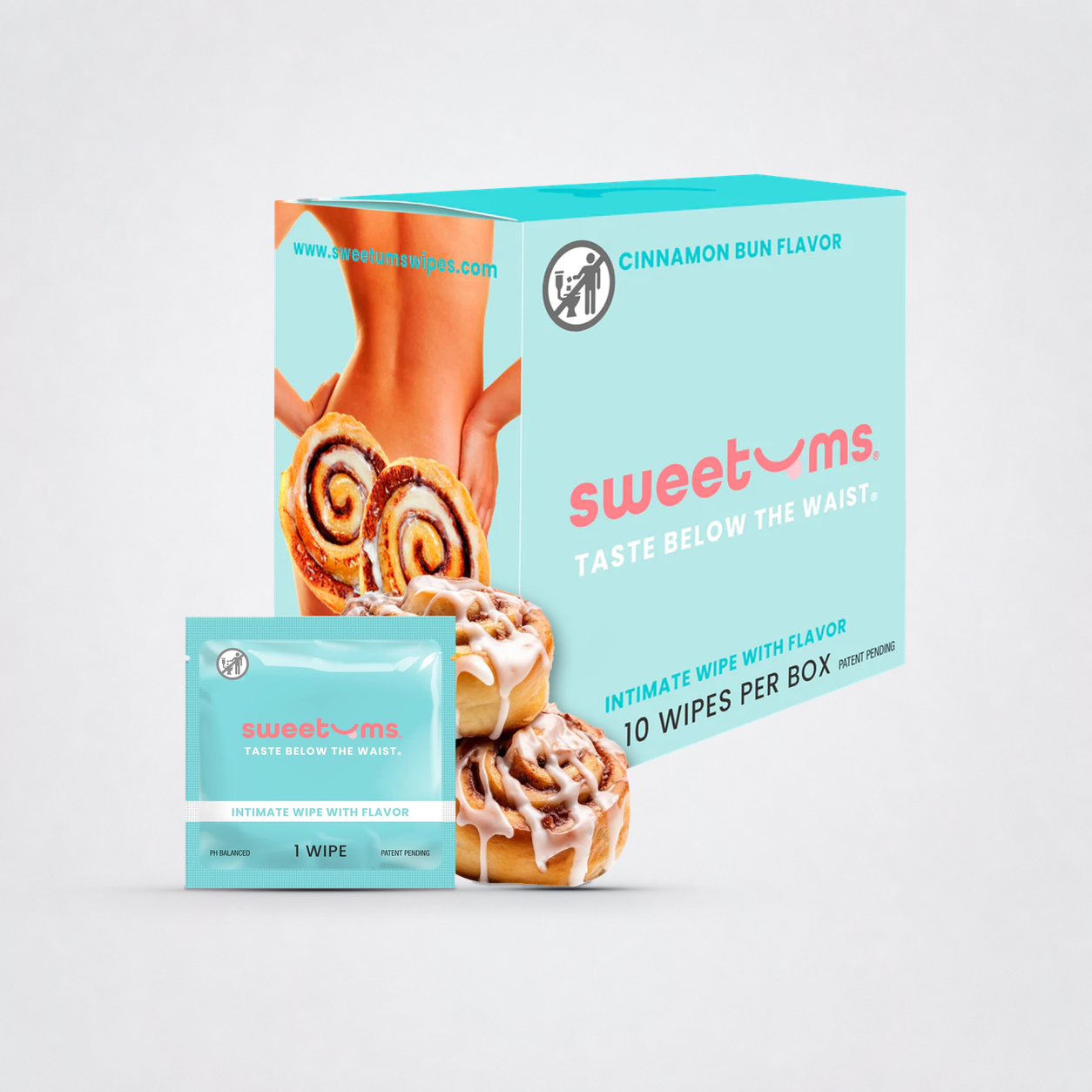 Sweetums Cinnamon Bun box and sachet with cinnamon rolls on grey studio background
