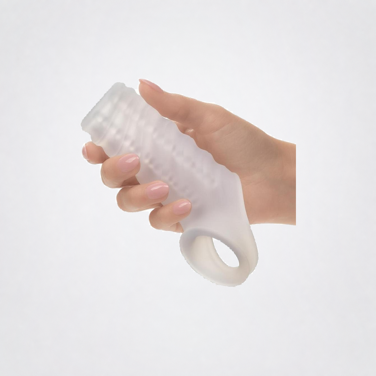 Hand holding the flexible clear silicone extender sleeve on a neutral studio background