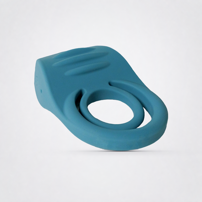 Angled view of the teal Ring My Bell double vibrating C-ring on a neutral grey studio background