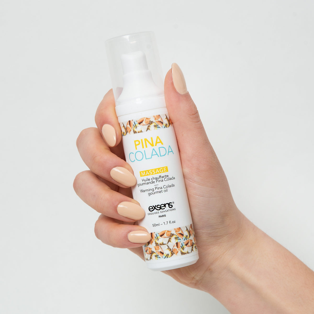 Piña Colada | Hand holding Exsens warming lickable massage oil bottle