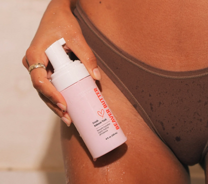 Person holding Beaver Butter Fresh Intimate Wash bottle beside their thigh