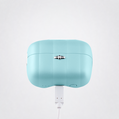 Pleasure Pod Air charging case connected to its original USB charging cord on The Luv Coach neutral grey studio background