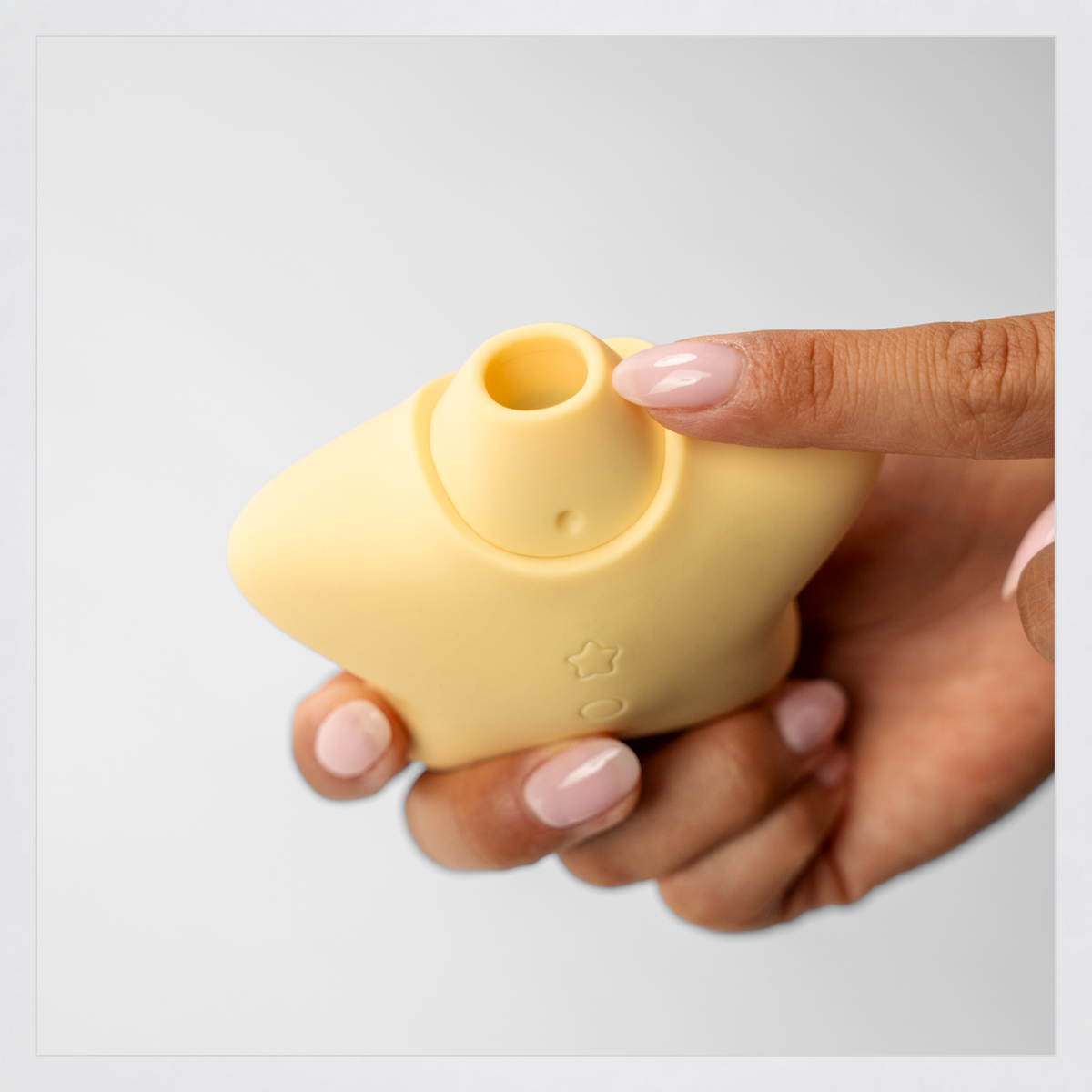 Star Power Airotic Vibrator shown in hand in a square grey-framed photo