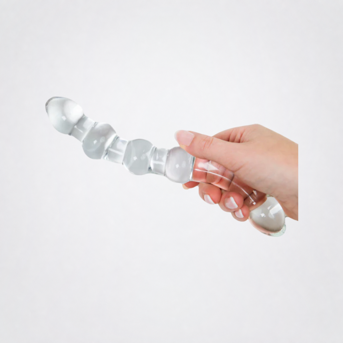 Temp and Tease ribbed glass dildo shown in hand on the Luv Coach grey studio background