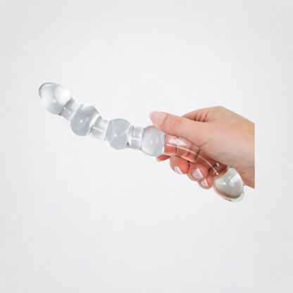 Temp and Tease ribbed glass dildo shown in hand on the Luv Coach grey studio background