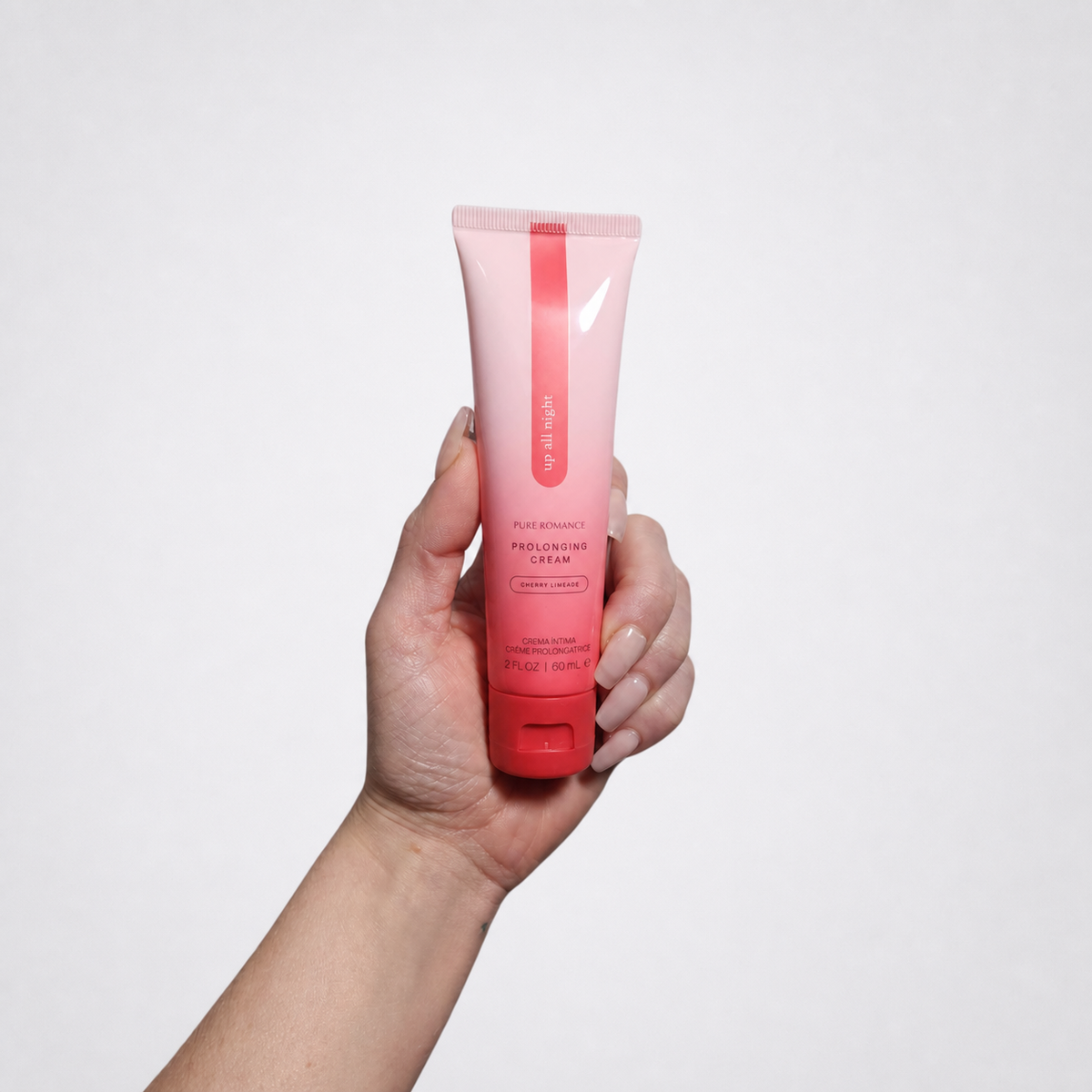Up All Night prolonging cream held in a hand on The Luv Coach approved gray studio background