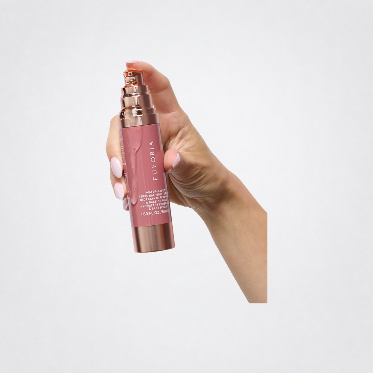 Hand holding Euforia Water-Based Personal Moisturizer on neutral grey background