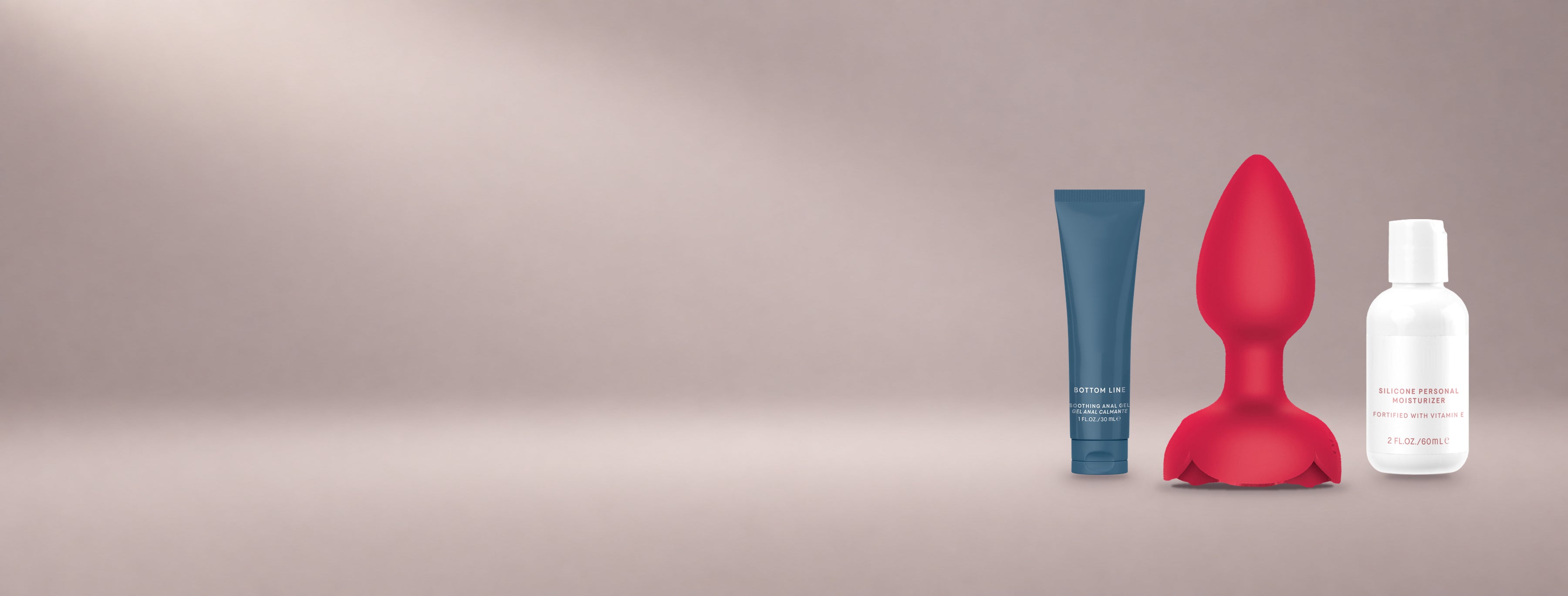Bottom Line gel, Rosebud Vibing Butt Plug and Silicone Personal Moisturizer arranged on a soft blush studio background.