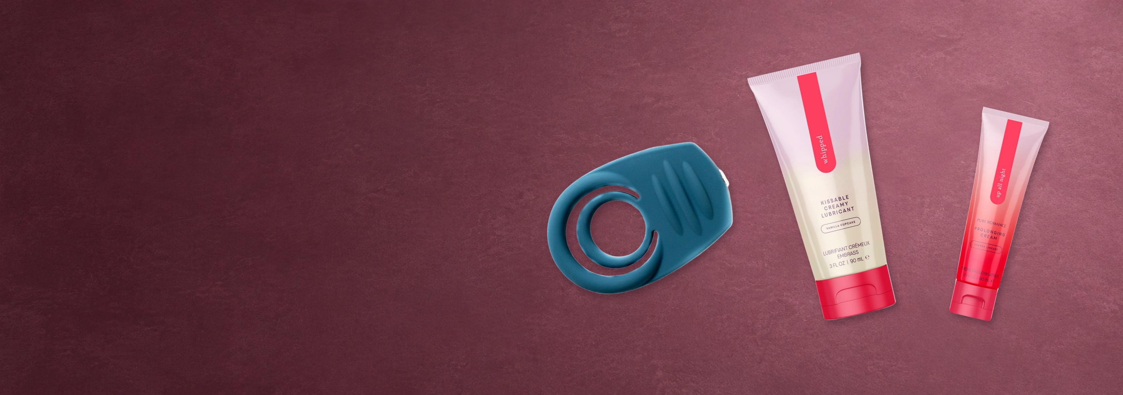 Blue vibrating ring, Whipped and Up All Night arranged flat on a berry surface.