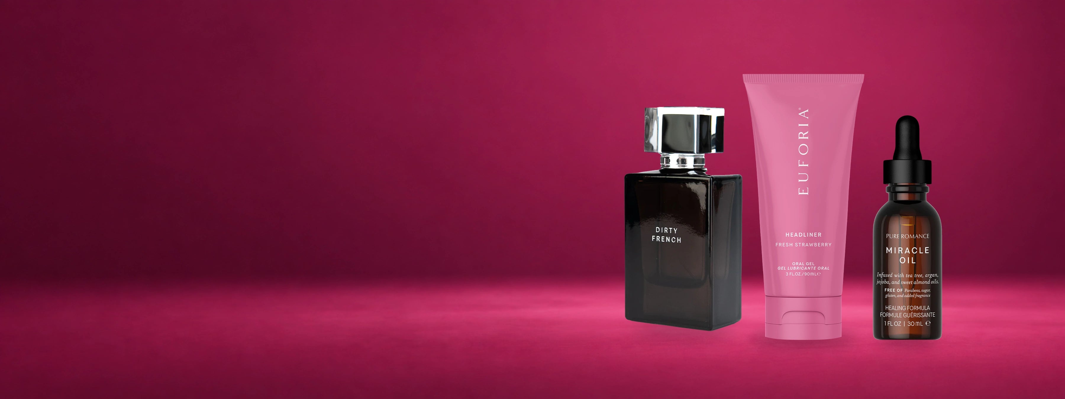 Dirty French fragrance, Euforia Fresh Strawberry oral gel and Miracle Oil arranged on a deep berry studio background.
